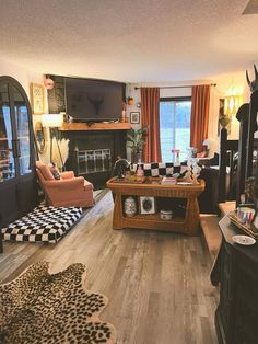 a living room filled with furniture and a flat screen tv on top of a wooden table