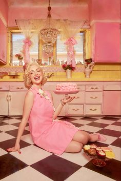 a woman sitting on the floor with a cake in front of her, holding a plate