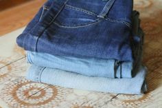 three pairs of jeans stacked on top of each other