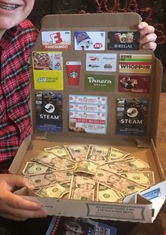 a young boy holding up a box full of money