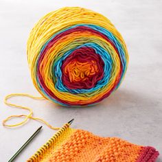 a ball of yarn next to a pair of knitting needles