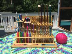 an array of knitting needles and crochet hooks on a table with a ball of yarn