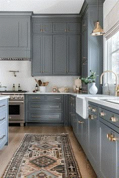 a kitchen with blue cabinets and an area rug