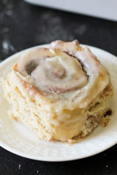 a piece of cinnamon roll sitting on top of a white plate