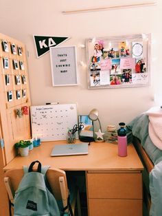 a desk with a laptop computer on top of it next to a bag and backpack