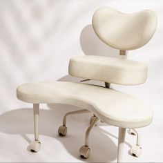 a white chair with wheels and a foot rest on it's back side, against a white background