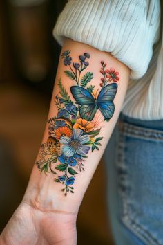 a woman's arm with butterflies and flowers on the left side of her arm