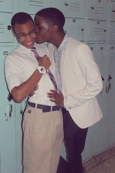 two young men standing next to each other in front of lockers with ties on