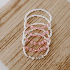 three beaded bracelets sitting on top of a wooden table