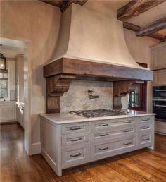 a large kitchen with an oven and wooden floors