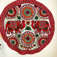 a red plate with elephants on it next to a lamp