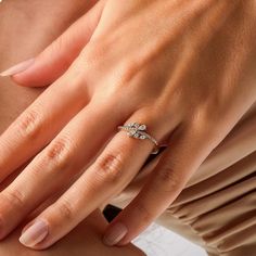 a woman's hand wearing a ring with three diamonds on the middle of her finger