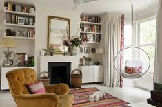 a living room filled with furniture and a fire place in front of a mirror on the wall