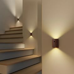 two lights on the wall next to some stairs