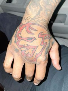 a man with a tattoo on his hand is sitting in the back seat of a car