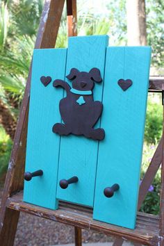 a wooden sign with a dog on it and hearts in the shape of a heart