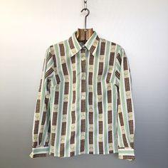 Beautiful 1970s vintage blouse. Brown houndstooth on beige + green stripes, this pattern is very unique; Slim fit, butterfly collar as it must be! Very cool and very classy. Material is polyester Condition is : mint vintage condition Size is FR42 in 1970 (refer to measurements) Do not hesitate to DM if you have any questions ! shoulder seam to shoulder seam : 39cm / 15,25in Armpit to armpit : 47cm / 18,5in Sleeve (shoulder seam to bottom) : 59cm / 23,25in Front length (collar to bottom) : 59cm / Retro Brown Top With Collar, Retro Brown Workwear Shirt, Retro Green Button-up Blouse, Retro Workwear Tops With Striped Collar, Retro Tops With Striped Collar For Work, Retro Green Cotton Blouse, Retro Fitted Green Shirt, Fitted Retro Green Shirt, Vintage Striped Collared Blouse