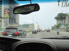 cars driving down the road in traffic on a sunny day