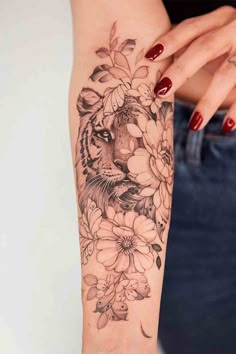 a woman's arm with flowers and a tiger on it