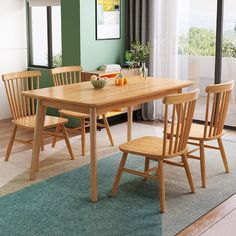 a dining table with four chairs and a bowl of fruit on it in front of a sliding glass door