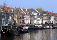 several boats are docked in the water near some buildings