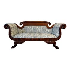 an old fashioned wooden couch with blue and white upholstered fabric on the back