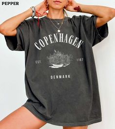 This Copenhagen Denmark comfort colors shirt is super soft and cozy. Perfect to lounge around, run errands, or walk your dog. ABOUT THIS SHIRT   ∙ Shirt is UNISEX and runs slightly large for ladies (For a relaxed fit, I suggest your usual size. For an oversized fit, I suggest sizing up 1 to 2 sizes.) ∙ 100% ring spun medium-weight cotton (soft-washed and garment-dyed) ∙ Colors may vary based on your monitor/screen display or lighting CARE INSTRUCTIONS ∙ Machine wash inside out in cold water ∙ Tu Christmas Graphic Tees, Christmas Graphic, Cool Ideas, Retro Stil, Jane Austen, Trending Now, Diwali, Comfort Colors, Original Design