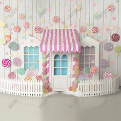 a paper house with lollipops hanging from it's roof and on the wall