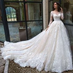 a woman in a white wedding dress standing on the ground next to a glass door