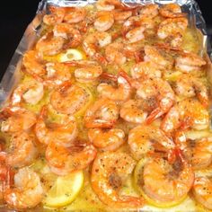 a casserole dish with shrimp and lemon slices