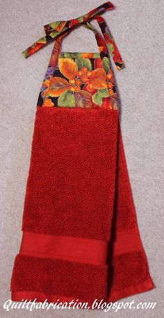 a red towel with an orange flower on it and a ribbon hanging from the top