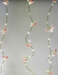 pink flowers with white lights hanging from the ceiling