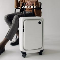 a man sitting on top of a white suitcase with the words monos above it