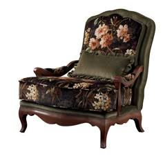 a chair that has flowers on it and green fabric around the armrests, along with a pillow