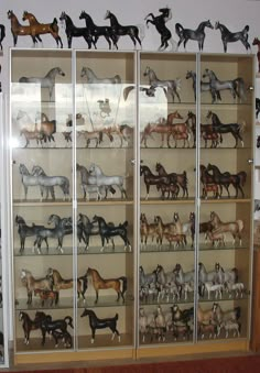 a display case filled with lots of different types of toy horses