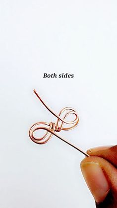 a hand holding a piece of wire with the word both sides on it