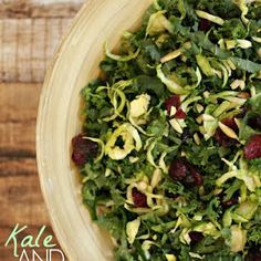 a bowl filled with greens and raisins on top of a wooden table