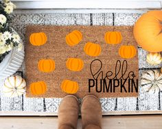 someone is standing in front of a door mat that says hello friends with pumpkins on it