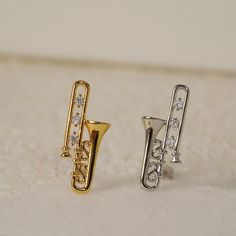 Material: High-Quality Metal with 18K Gold-Plated Finish Accents: Sparkling Zircon Design: Trombone Stud Earrings Occasion: Suitable for casual and formal wear Packaging: Comes in a premium gift box, ready for gifting Trombone Earrings, Funky Sweaters, Instrument Jewelry, Musical Gifts, Musical Gift, 18k Gold Earrings, Earrings Dainty, Trombone, Premium Gift