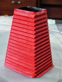 a red vase sitting on top of a table