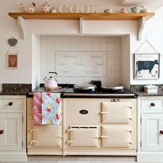 an old fashioned stove in a kitchen with lots of counter space and decor on the top shelf