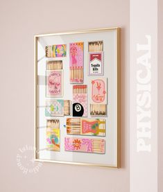 a framed photo with matches and matchsticks in it on the wall next to a pink wall