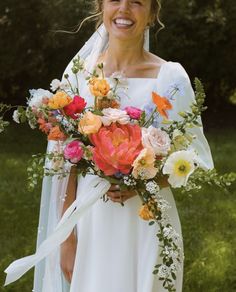 a woman in a wedding dress holding a bouquet of flowers