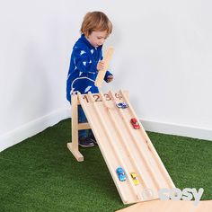 a little boy playing with a wooden slide