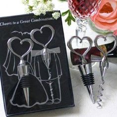 two wine bottle stoppers in the shape of hearts with corkscrews attached to them