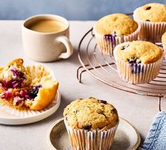 blueberry muffins on a plate next to a cup of coffee