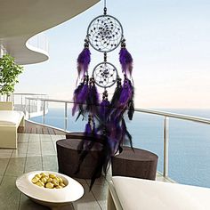 the balcony is decorated with white furniture and purple feathers