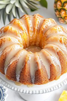 a bundt cake sitting on top of a white plate next to pineapples