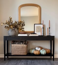 a black table with some pumpkins and a mirror