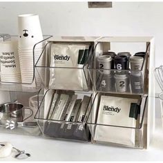 an organized shelf with coffee cups and other kitchen items